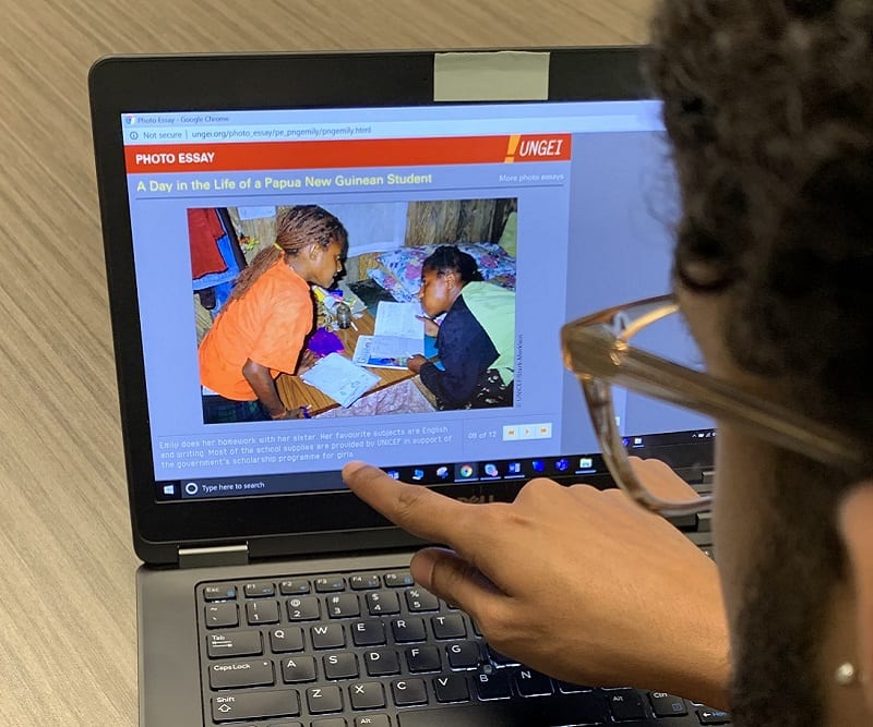 Student reads an online photo essay about girls' schooling in different countries